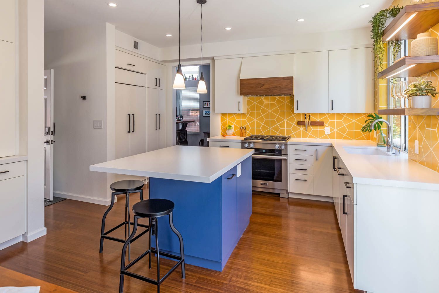 White and blue cabinets are paired with the yellow wall in this kitchen remodel